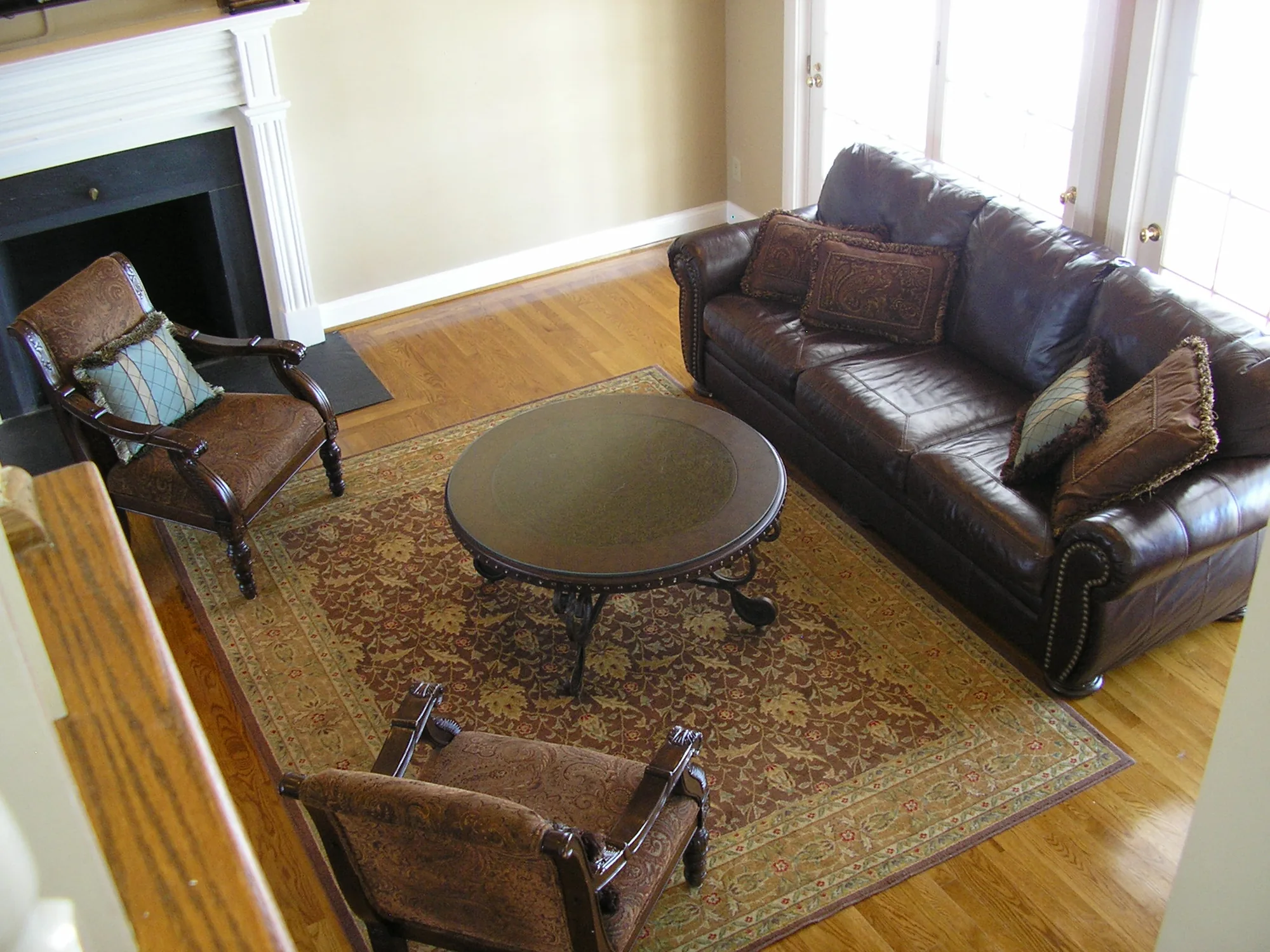 A sitting room with leather armchairs and a round wooden table